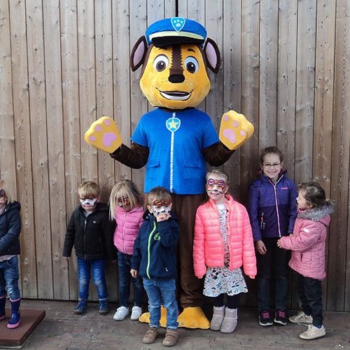 Person in Paw Patrol suit with a bunch of kids around him/her